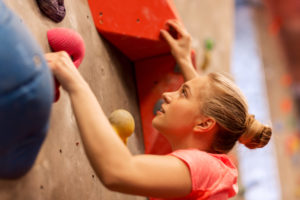 young woman exercising at indoor climbing gym