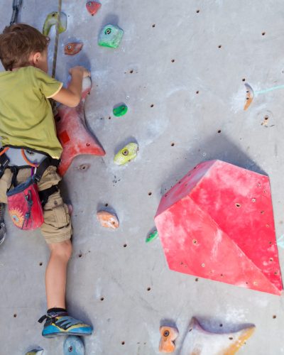 little boy climbing a rock wall