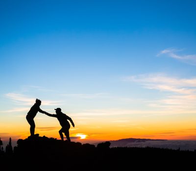 Teamwork couple climbing helping hand